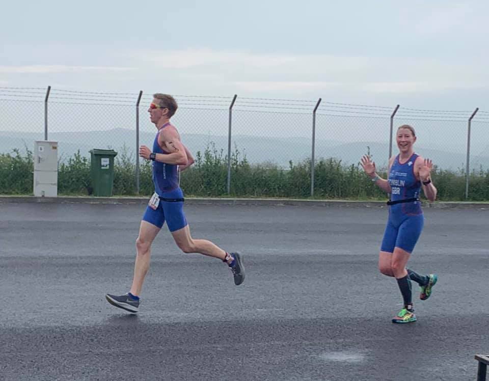 Brother and sister Tom and Jenni Anderson on the run section of a triathlon wearing their team Great Britain kit.