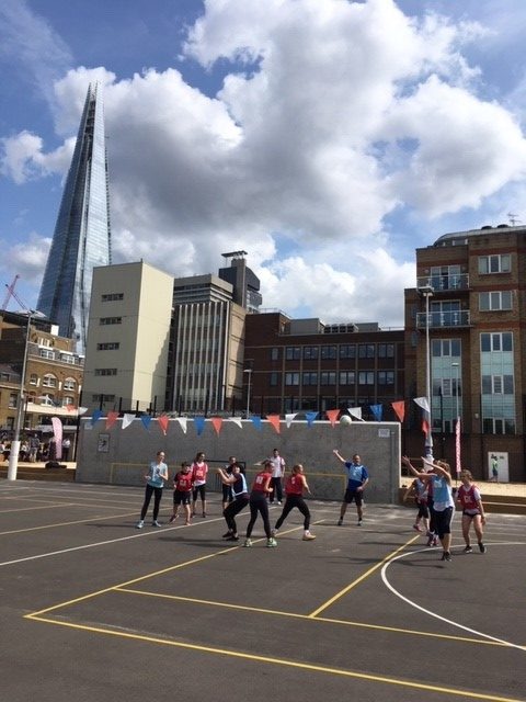Group of people playing Netball on a netball court