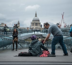 London millennium bridge with a homeless person and another person giving them something